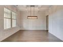Dining room featuring coffered ceilings, wainscotting and an elegant light fixture at 145 Bre Dr, Fayetteville, GA 30215