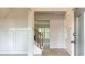 Elegant foyer with custom wall paneling, hardwood floors and staircase with wrought iron spindles at 145 Bre Dr, Fayetteville, GA 30215