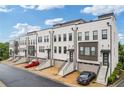Street view of luxury townhomes showcasing their painted brick facade and individual garages at 830 Stone Ridge Ln, Atlanta, GA 30324