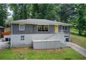 Charming home with gray brick, a vibrant yellow door, and front yard at 2564 Riggs Dr, East Point, GA 30344