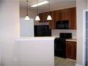 Well-lit kitchen features dark cabinets, black appliances, and pendant lighting at 3500 Sweetwater Rd # 522, Duluth, GA 30096