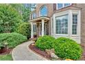 Close-up view of home's entrance featuring a welcoming walkway and lush landscaping with colorful flowers at 4012 Ironhill Ln, Woodstock, GA 30189