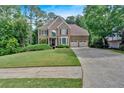 Inviting two-story home with well-kept lawn, mature trees, and a driveway leading to an attached garage at 4012 Ironhill Ln, Woodstock, GA 30189