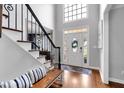 Bright foyer with hardwood floors, staircase, and a view of the front door and upper window at 4012 Ironhill Ln, Woodstock, GA 30189
