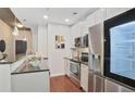 Contemporary kitchen boasts stainless steel appliances and sleek, white cabinetry at 855 Peachtree Ne St # 1311, Atlanta, GA 30308