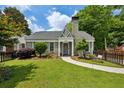 Beautiful brick home with lush green lawn, complemented by a decorative black picket fence at 129 2Nd Se Ave, Atlanta, GA 30317