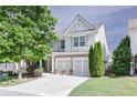 Charming home with a two-car garage, stone accents, manicured lawn, and mature landscaping at 5730 Weddington Dr, Cumming, GA 30040
