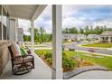Relaxing rocking chairs on the front porch overlook the neighborhood street at 7730 Demeter Dr, Fairburn, GA 30213