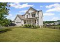 Beautiful two-story home featuring a spacious front yard, a front porch and attached two car garage at 7095 Evening Dew Dr, Cumming, GA 30028