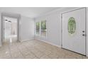 Bright foyer with tile flooring, large window, and a decorative front door leading into the home at 1447 High Sierra Dr, Lawrenceville, GA 30043
