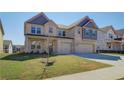 Inviting two-story house showcasing a brick facade, double garage, and green front lawn at 2436 Cadenza Cir, Dacula, GA 30019