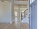 Inviting foyer with light wood floors, staircase with iron railings, and neutral paint at 2436 Cadenza Cir, Dacula, GA 30019