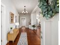 Inviting foyer featuring hardwood floors, shiplap walls, a modern chandelier, and a view into the kitchen and living areas at 11 Pine St, Covington, GA 30014
