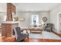 Stylish living room with hardwood floors, brick fireplace, white shiplap walls, and comfortable seating arrangement at 11 Pine St, Covington, GA 30014