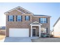 Traditional brick home with a manicured lawn and attached garage at 11562 Creekstone Rd, Hampton, GA 30228
