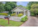 Quaint home featuring a white picket fence and a well-maintained lawn, blending charm with curb appeal at 1265 Woodland Se Ave, Atlanta, GA 30316