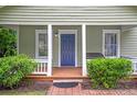 Charming home with a covered porch, manicured bushes, and a classic front door at 1265 Woodland Se Ave, Atlanta, GA 30316