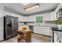 Bright kitchen featuring white cabinets, granite countertops, and stainless steel appliances at 410 Lima Ct, Woodstock, GA 30188