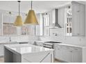 Bright, modern kitchen with gray cabinetry, white countertops, stainless steel appliances, and stylish pendant lighting at 100 Sheridan Dr, Atlanta, GA 30305