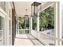 Inviting outdoor porch with wooden floors and white railing, featuring elegant lighting fixtures and peaceful views at 100 Sheridan Dr, Atlanta, GA 30305