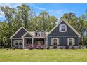 Charming craftsman home with a manicured lawn and lush landscaping, set against a picturesque blue sky at 30 Deer Creek Ct, Moreland, GA 30259