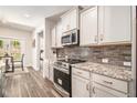 Modern kitchen featuring stainless steel appliances, granite countertops, and stylish white cabinets, perfect for cooking at 30 Deer Creek Ct, Moreland, GA 30259