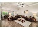Spacious living room with hardwood floors, a ceiling fan, and a comfortable leather sofa set, exuding modern elegance at 30 Deer Creek Ct, Moreland, GA 30259