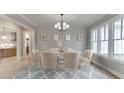 Formal dining room featuring elegant wainscoting, chandelier, and natural light at 7625 Breeze Bay Rd, Cumming, GA 30041