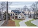 Stunning exterior view of brick home with a long driveway and mature trees at 7625 Breeze Bay Rd, Cumming, GA 30041