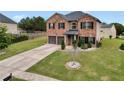 Charming two-story brick home with a well-manicured lawn and a two-car garage at 85 Foxgrove Cv, Covington, GA 30014