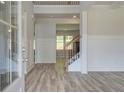 Elegant entryway with wood-look floors, decorative wainscoting and a staircase with iron balusters at 2780 Dolce Rd, Dacula, GA 30019