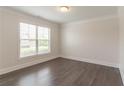 Bedroom with wood floors, white trim, and a large window at 2910 Hampton Grove Trce, Dacula, GA 30019