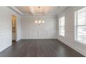 Elegant dining room with dark hardwood floors, decorative wainscoting, and a coffered ceiling at 2910 Hampton Grove Trce, Dacula, GA 30019