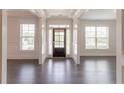 Bright foyer featuring dark hardwood floors, white trim, and a front door with glass panels at 2910 Hampton Grove Trce, Dacula, GA 30019