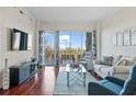 Bright living room featuring hardwood floors, a balcony, and views of the surrounding area at 2950 Mount Wilkinson Se Pkwy # 505, Atlanta, GA 30339
