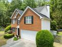 Aerial view of a two-story brick home with a well-manicured lawn and driveway at 5404 Trumpet Vine Se Trl, Mableton, GA 30126
