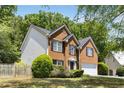 Side view of a two-story brick home with black shutters and a manicured lawn at 5404 Trumpet Vine Se Trl, Mableton, GA 30126