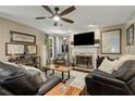 Cozy living room with a fireplace, mounted TV, ceiling fan, and comfortable seating at 5404 Trumpet Vine Se Trl, Mableton, GA 30126