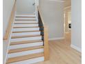 Elegant staircase with white risers, wood treads, and a modern black railing at 5611 Meadowstone Walk, Kennesaw, GA 30152