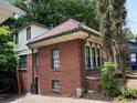 Brick home showcasing a red tile roof, green trim, and a bright and cheery two-story addition at 1225 Cameron Ne Ct, Atlanta, GA 30306