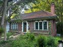 Brick home featuring arched windows, a red tile roof, and an elegant entrance, set in a leafy neighborhood at 1225 Cameron Ne Ct, Atlanta, GA 30306