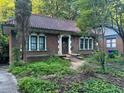 Inviting brick home with a red tile roof, arched windows and front porch, nestled among mature trees at 1225 Cameron Ne Ct, Atlanta, GA 30306