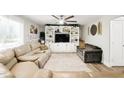 Spacious living room featuring plush sofas, a ceiling fan, and a custom built-in entertainment center at 1430 Mineral Springs Rd, Hoschton, GA 30548