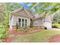 Beautiful home with stone accents, neutral siding, a two-car garage, and lush landscaping at 4460 Delano Dr, Cumming, GA 30040