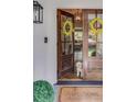Close-up of the inviting, glass paneled front door with yellow wreaths, opening into the living area. A small dog is waiting inside at 1343 Peachtree Battle Nw Ave, Atlanta, GA 30327