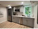 Updated kitchen with grey cabinets, stainless steel appliances, and a view to the backyard through the bright window above the sink at 1343 Peachtree Battle Nw Ave, Atlanta, GA 30327