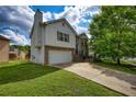 Two-story home with attached garage, and well-manicured lawn with tree at 2000 Redwood Trce, Ellenwood, GA 30294