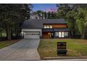 Modern two-story home with a dark roof, light wood accents, and a long driveway at 5346 Kelleys Mill Cir, Stone Mountain, GA 30088