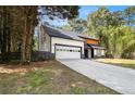 Modern two-story home with a dark roof, light wood accents, and an attached garage at 5346 Kelleys Mill Cir, Stone Mountain, GA 30088