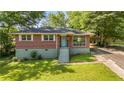 Inviting brick home with a bright blue front door and lush green lawn at 765 Shellnut Dr, Forest Park, GA 30297